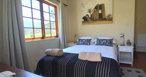 a bedroom with a bed and a window at Koedoeskloof Guesthouse in Ladismith