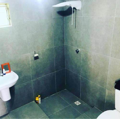 Un baño con ducha, inodoro y lavabo. en Cabana Solitude - Concha, en Florianópolis