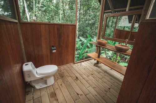 baño con aseo en una terraza de madera en La Manigua Lodge, en La Macarena