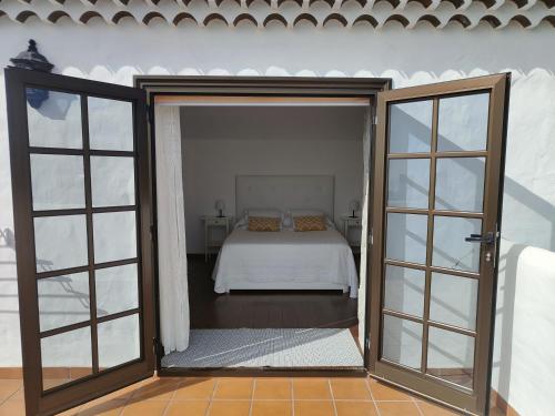 1 dormitorio con 1 cama y puertas correderas de cristal en Sunset Las Hadas, en Candelaria