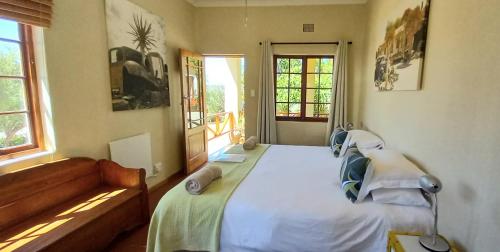 a bedroom with a large white bed with a window at Koedoeskloof Guesthouse in Ladismith