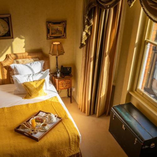 a hotel room with a tray of food on a bed at San Domenico House in London