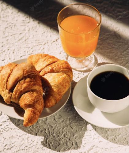 a plate of pastries and a cup of coffee and a glass of orange juice at Hotel restaurant LA PLACE in Saint-Amand-Montrond
