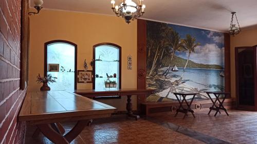 ein Esszimmer mit einem Tisch und einem Gemälde an der Wand in der Unterkunft Pousada Praia Sol do Indaiá in Bertioga
