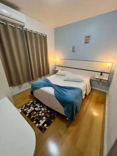 Un dormitorio con una cama con una manta azul. en Pousada Cinnamon, en Canela