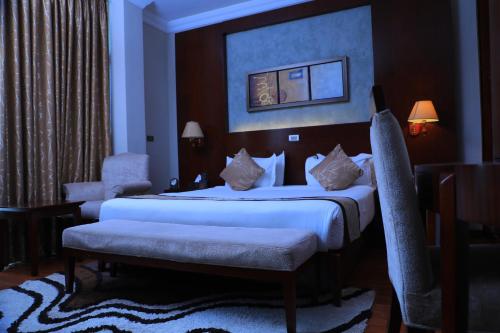 a hotel room with a bed and a chair at Sidra International Hotel in Addis Ababa