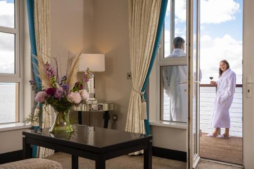 a woman standing on a balcony in a hotel room at Redcastle Hotel in Moville