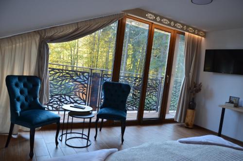 1 dormitorio con 1 cama y 2 sillas y balcón en Horská Chata Suchý vrch, en Banská Bystrica