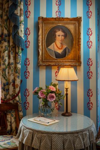 a table with a vase of flowers and a painting at San Domenico House in London