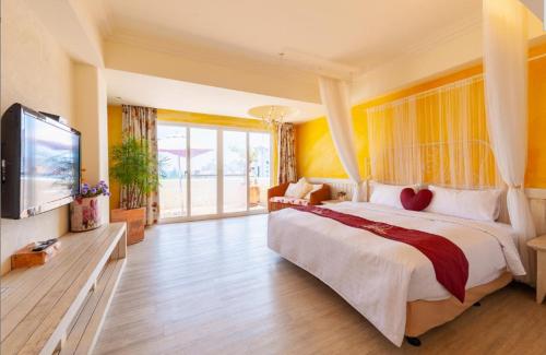 a bedroom with a large bed and a flat screen tv at Banani Resort By WB Inn in Gosāba
