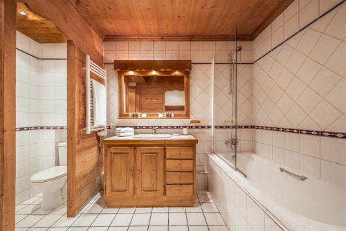 ヴァル・ディゼールにあるMadame Vacances Chalet La Grande Sassièreの洗面台、浴槽、トイレを備えたバスルーム
