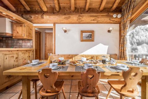 une salle à manger avec une table et des chaises en bois dans l'établissement Madame Vacances Chalet La Grande Sassière, à Val dʼIsère