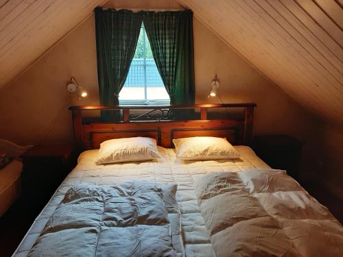 a large bed in a room with a window at Sjönära Ullared in Ullared