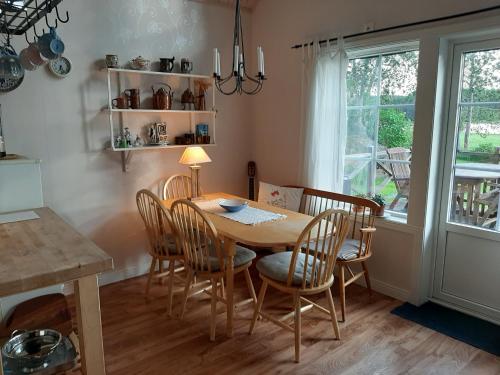 a dining room with a table and chairs and a window at Sjönära Ullared in Ullared