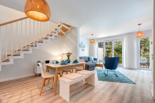 a living room with a dining room table and stairs at Bernsteinquartier BQ 9c Ostseenest in Kolpinsee