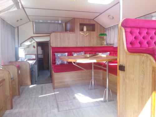 a dining area in an rv with a table at BATEAU - Jolie pénichette sur région touristique. in Bellegarde