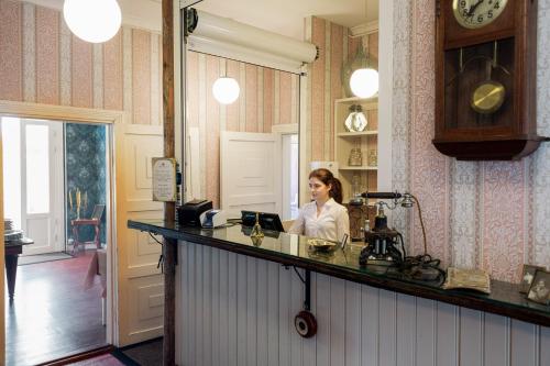 a woman sitting at a counter in a kitchen at Tammiston Cottages in Naantali