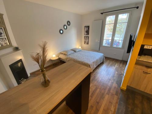 a bedroom with a bed and a desk in a room at Superbe T2 entre Paris et Disney (RER A) in Nogent-sur-Marne