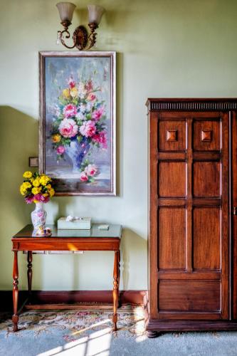 a painting of flowers on a wall next to a table at Karan Mahal in Srinagar