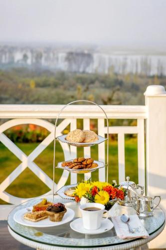 a plate of food on a glass table with food at Karan Mahal in Srinagar