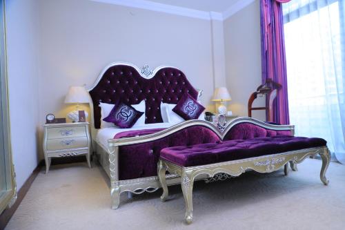 a bedroom with a purple bed and a purple bench at Sidra International Hotel in Addis Ababa
