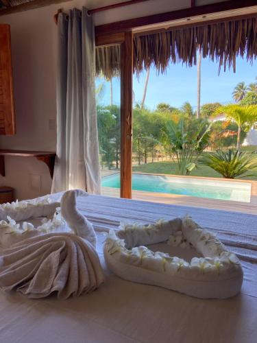 a bedroom with two beds with a view of a pool at Tiki Pool's Bungalows in Fortim