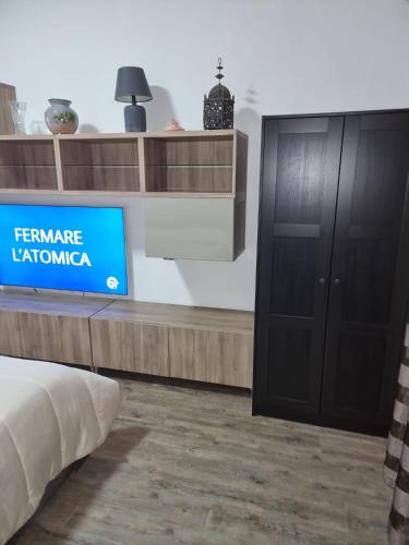 a room with a tv and a bed and a sign at Sognando Positano in Naples