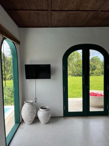 a room with two vases sitting next to a door at Woywoy Escape Samu (Adults Only) in Ubud