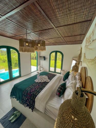 a bedroom with a large bed and some windows at Woywoy Escape Samu (Adults Only) in Ubud