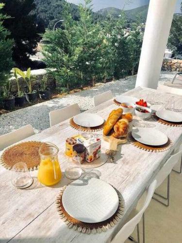 a wooden table with food and drinks on it at Balinese Villa near the beach outdoor jacuzzi in Cala Llonga