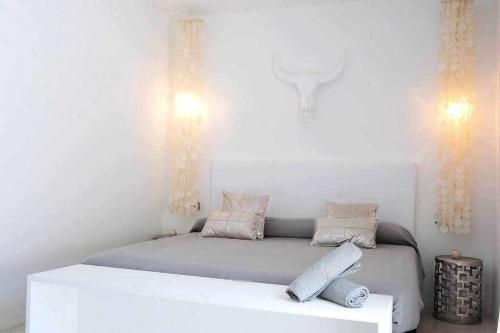 a white bedroom with a bed with two pillows at Balinese Villa near the beach outdoor jacuzzi in Cala Llonga