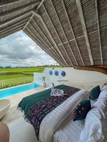 a bedroom with a bed and a swimming pool at Woywoy Escape Samu (Adults Only) in Ubud