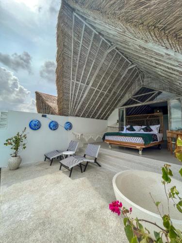 a bedroom with a bed and chairs on a patio at Woywoy Escape Samu (Adults Only) in Ubud