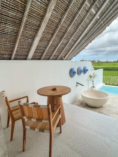 a room with a table and a sink and a chair at Woywoy Escape Samu (Adults Only) in Ubud