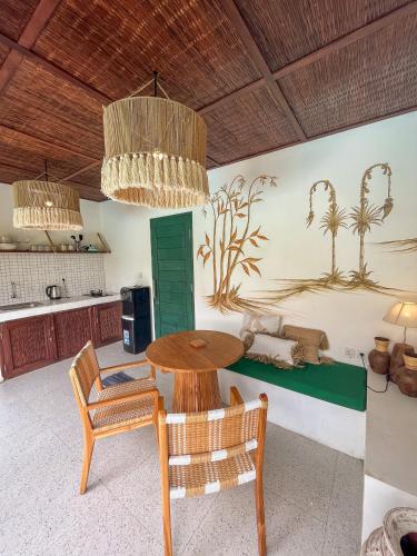 a kitchen with a table and chairs in a room at Woywoy Escape Samu (Adults Only) in Ubud