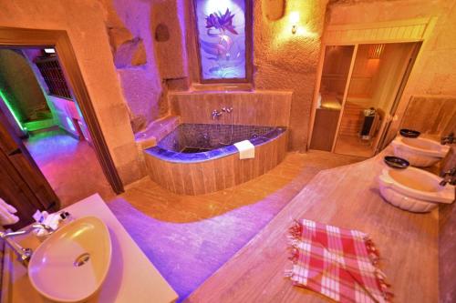 a bathroom with a tub and a toilet and a sink at La Perla Cave Cappadocia in Urgup