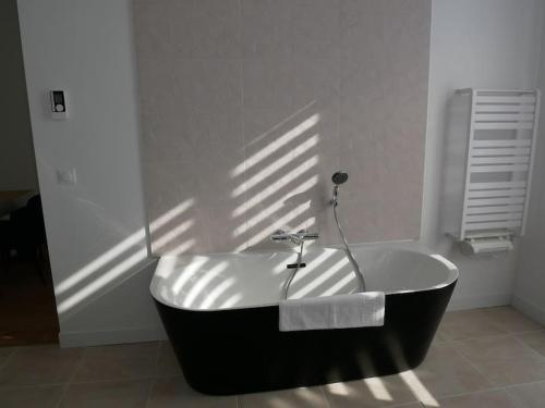 a black and white bath tub in a bathroom at Clos de la Providence, gîte, piscine et Spa 3 chambres in Nolay