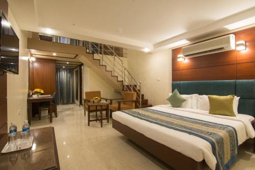 Shenbaga Hotel And Convention Centre tesisinde bir odada yatak veya yataklar
