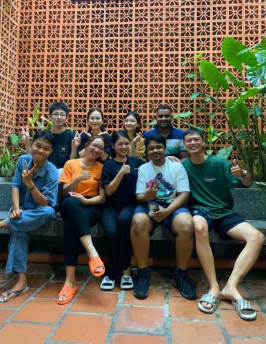 a group of people sitting on a bench posing for a picture at City Hostel Da Nang in Da Nang