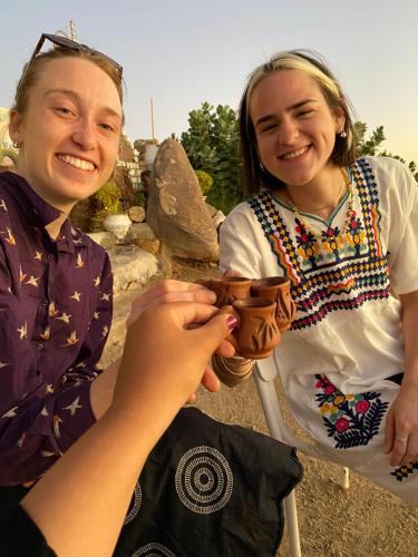 a woman is handing another woman a wallet at Heissa Hostel in Aswan
