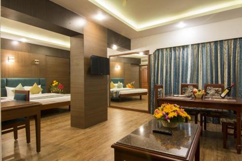 a room with two beds and a living room at Shenbaga Hotel And Convention Centre in Puducherry
