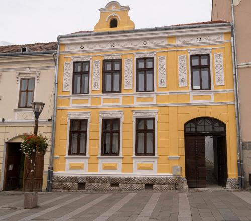 a yellow building with a tower on top of it at Zengő in Miercurea-Ciuc