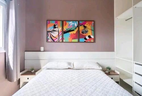 um quarto com uma cama e um quadro na parede em apartamento cobertura , proximo a praia grande , Ubatuba em Ubatuba