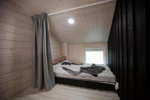 een kleine kamer met een bed in een hut bij Korpi in Äkäslompolo