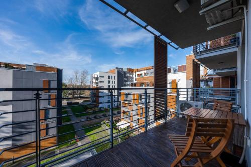 a balcony with a wooden table and chairs on a building at Apartamenty Tespis - Francuska Atal Park in Katowice