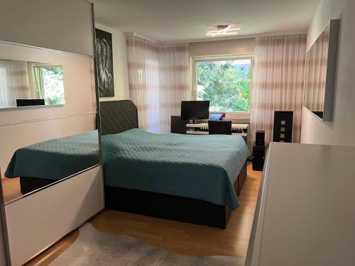 a bedroom with two beds and a desk and a window at Deluxe Apartment Baden-Baden in Baden-Baden