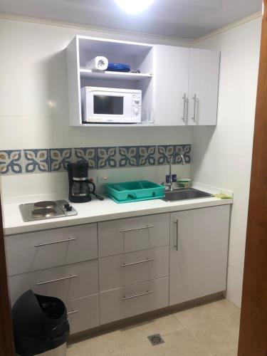 cocina con armarios blancos y microondas en Apartamentos en San Andres a 1 Cuadra de la Playa en el Centro, en San Andrés