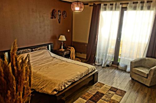 Un dormitorio con una cama y una silla y ventanas. en le Patchwork-Loft calme et cozy+parking privé, en Toulouse