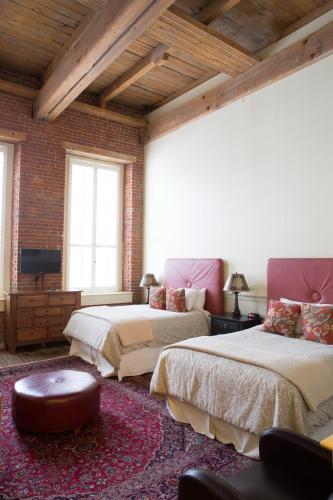 a bedroom with two beds and a tv in it at The Common Man Inn & Restaurant in Claremont