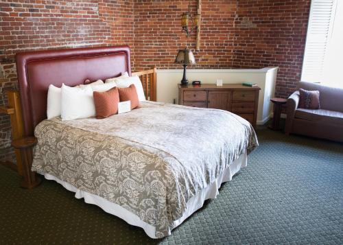 a bedroom with a bed and a brick wall at The Common Man Inn & Restaurant in Claremont